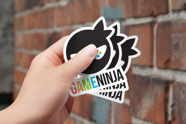 A hand holding stickers of a video game company logo