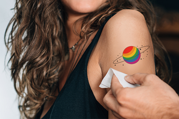 Pride-themed being applied to a woman